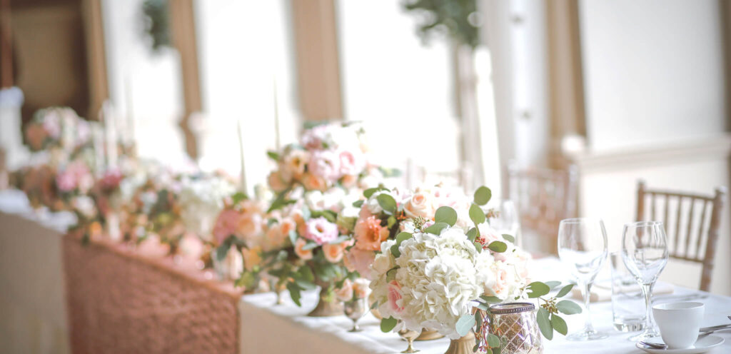 Elegant wedding table adorned with lush floral arrangements and delicate greenery, creating a romantic and sophisticated ambiance
