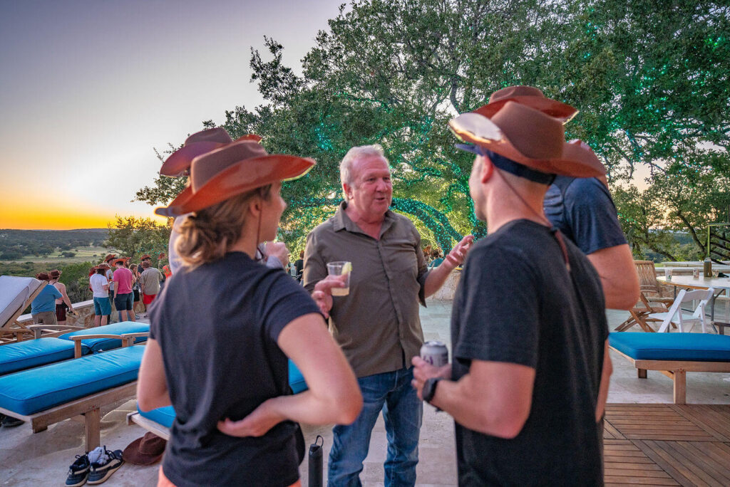 Corporate team enjoying sunset cocktails by the pool at Artemis Ranch
