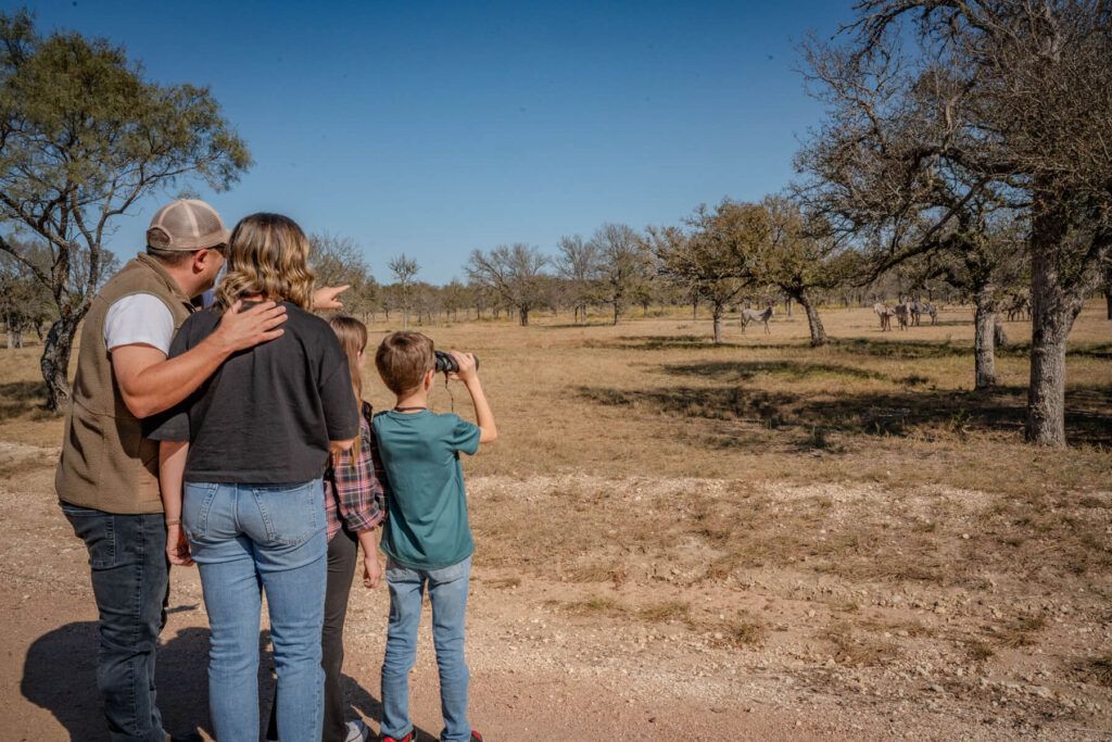 family on a safari wildlife spotting adventure experience with binoculars and photography
