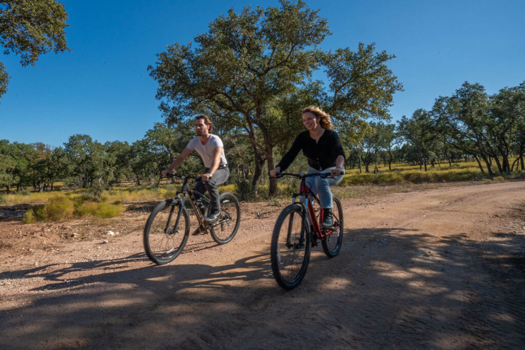 a couple riding mountain bikes on a ranch trail