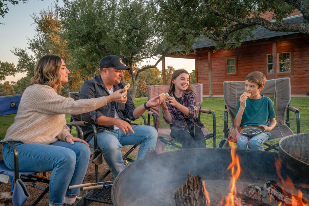 parents and kids making smores over the campfire