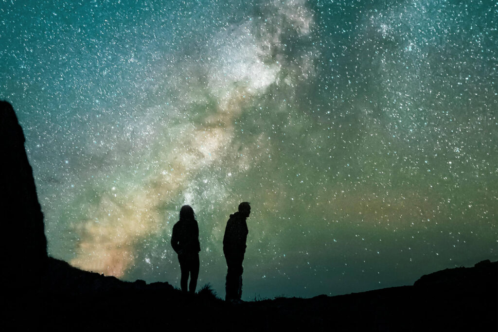 couple silhouetted against spectacular dark sky stargazing experience