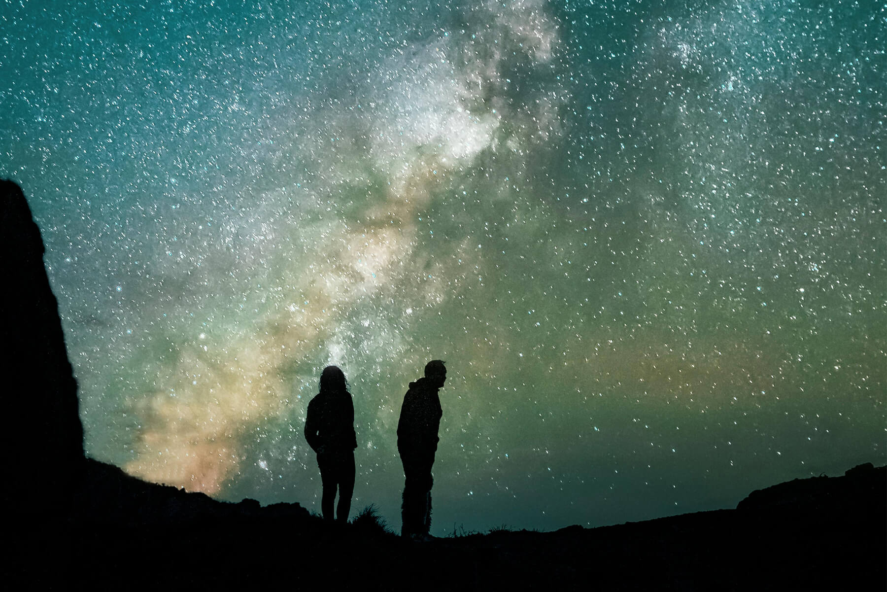 couple silhouetted against spectacular dark sky stargazing experience