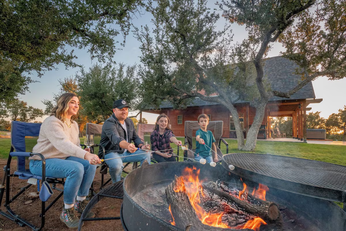 Pair your stay at Artemis Cottage - family roasting marshmallows at the fire pit