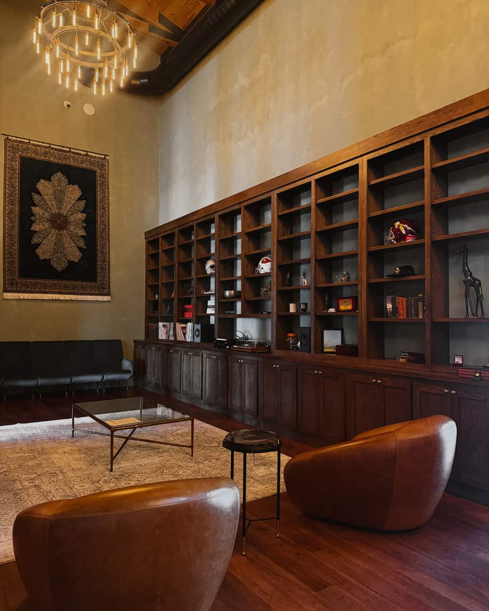 Artemis Lodge great room with built-in library shelves, chandelier and leather chairs