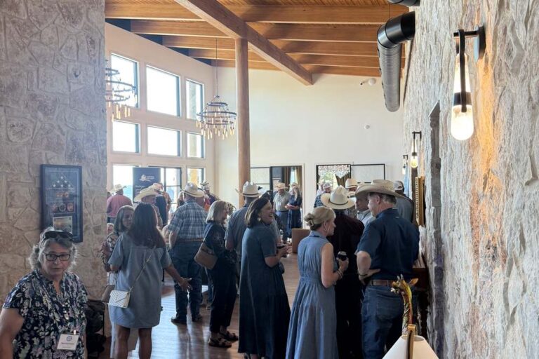 Guests gathering for a corporate event in the stone and timber event hall at Artemis Ranch & Retreat
